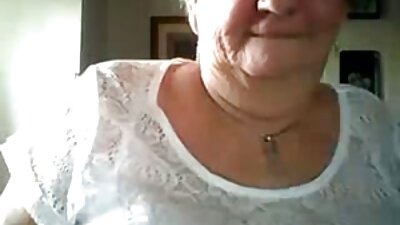En kvinna med svart hår får sin fitta in på sängen